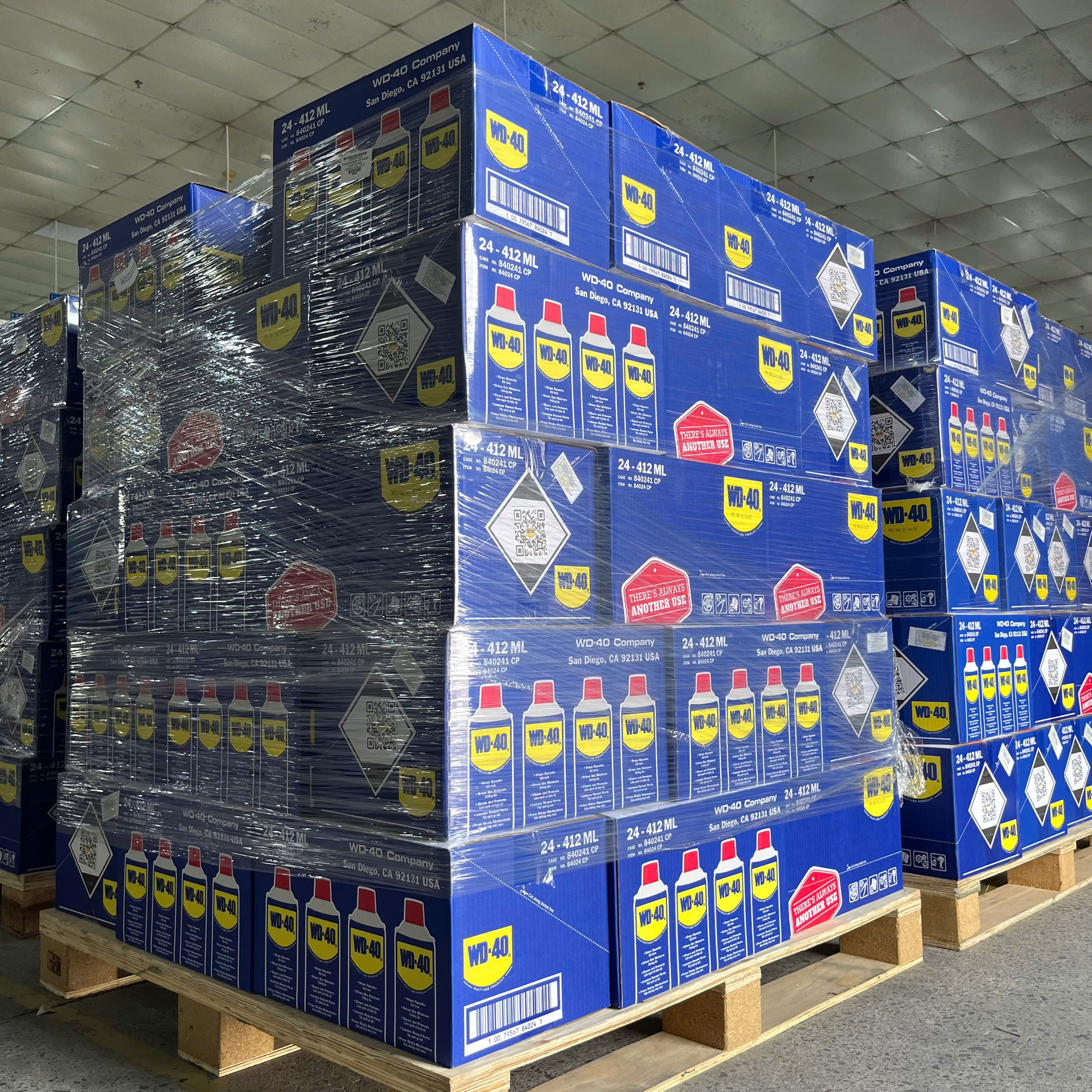Hình ảnh so sánh chai WD-40 chính hãng và giả. Bên trái: Chai chính hãng màu xanh đậm, logo sắc nét, vòi Smart Straw. Bên phải: Chai giả màu nhạt, logo mờ, vòi kém chất lượng.